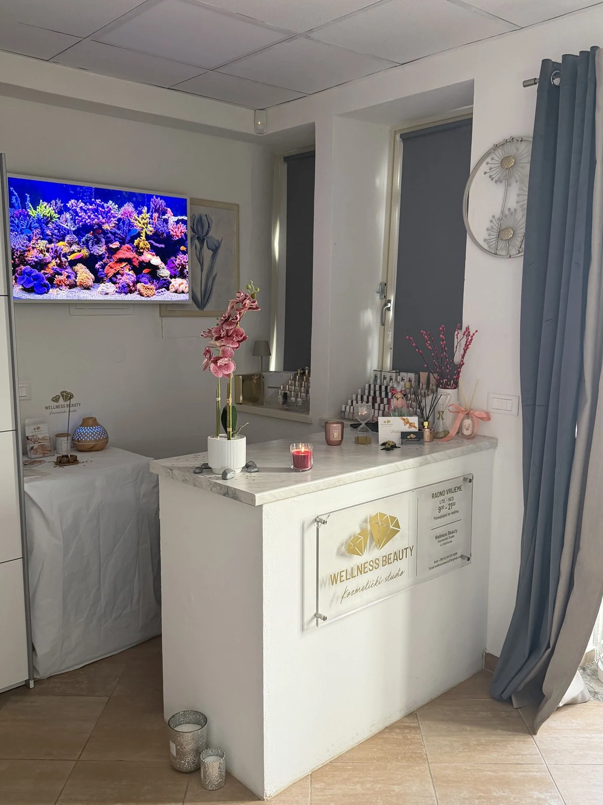 Recepcija s logotipom Wellness Beauty, pultom i akvarijem